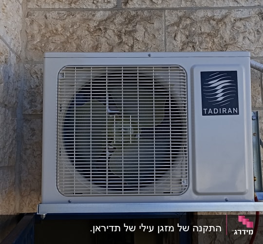 יחידת מזגן חיצונית מותקנת על קיר אבן